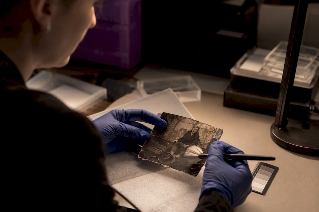 Hands restoring degraded forensic photograph