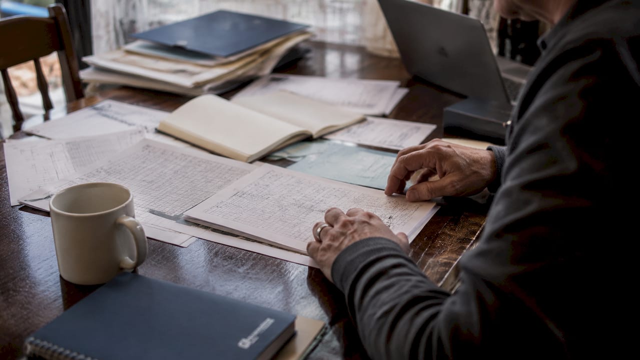 Hands sorting genealogical cold case records