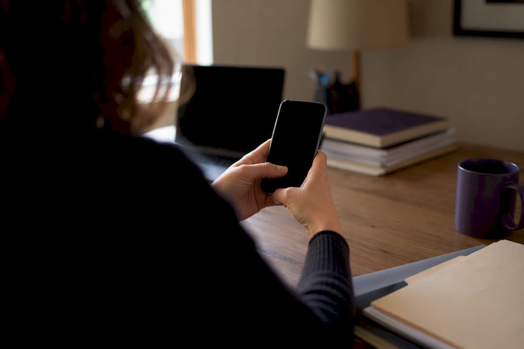 Hands holding smartphone preparing to use reverse image search