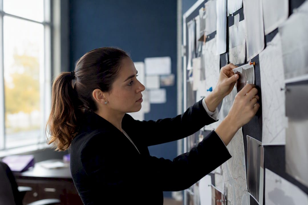 Investigator pinning photo on evidence board