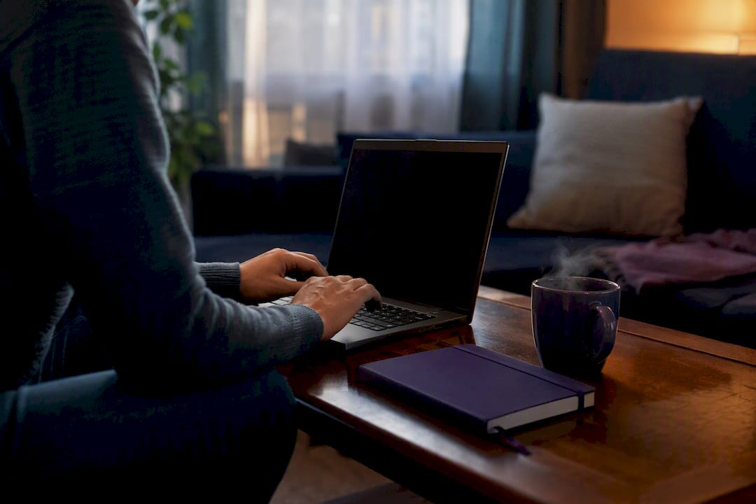 Hands poised near blank laptop in home research setting